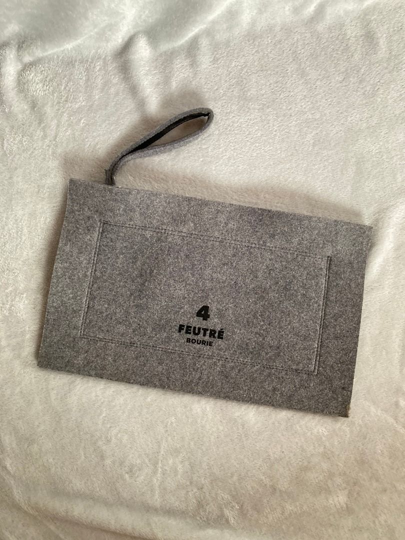 Grey Felt Zip Pouch Clutch (Category: Purses & Pouches) located in Rizal. Submitted by sheeraay (Listing ID 1467706943, Image 1). Description: - Brand: FEUTRÉ - Material: Soft grey felt with clean interior lining - Closure: Smooth silver top zipper - Design: Minimalist and slim profile - Details: Stitched brand label inside - Condition: Excellent.