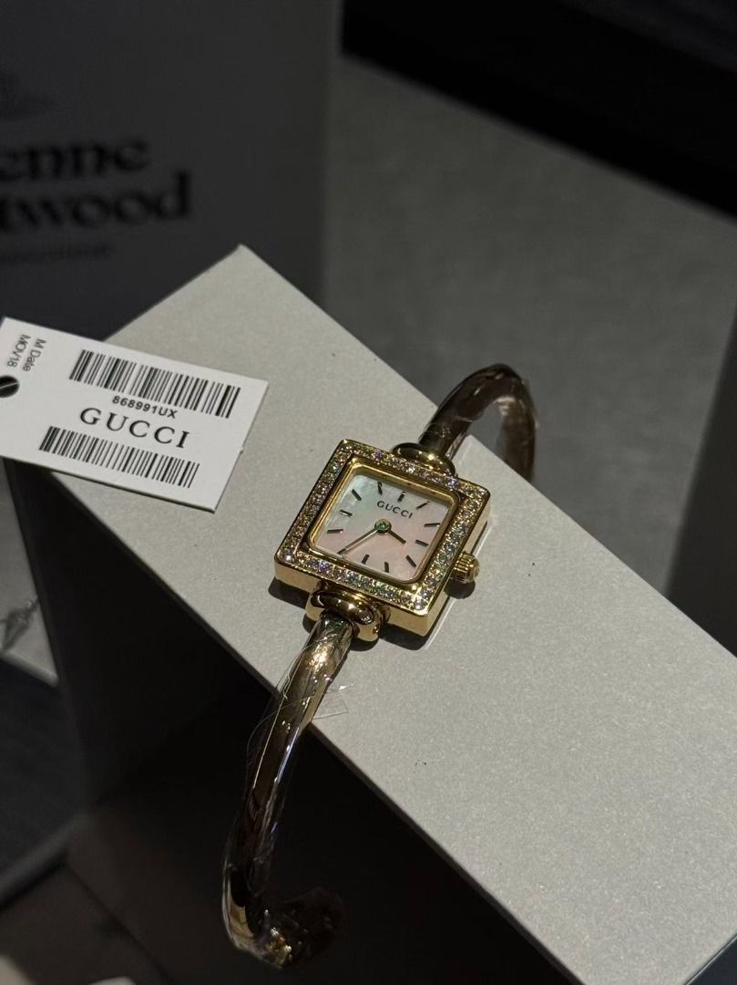 Gucci Bangle Watch with Diamond Bezel (Category: Women's Watches) located in Pateros City. Submitted by purebird_714be0 (Listing ID 1467693449, Image 3). Description: Gucci bangle watch set featuring square bezels encrusted with crystals. Gold-tone hardware with protective plastic wrap still on the cuffs. Multiple dial color options available including white, black, pink, and mother-of-pearl. Swiss made movement. Tag attached with code 868991UX. 