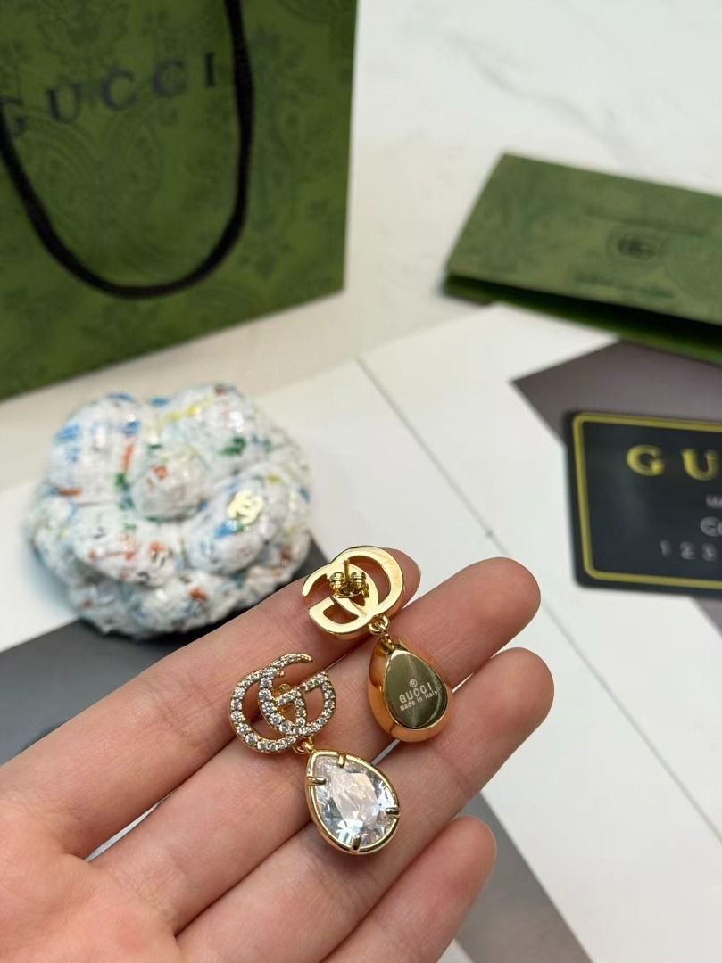 Gucci GG Crystal Drop Earrings (Category: Earrings) located in Davao. Submitted by colacodawr20358 (Listing ID 1467687406, Image 3). Description: - Authentic Gucci gold-tone earrings - Features crystal-encrusted Double G logo with dangling large teardrop crystals - Secure post back closure - Hallmarked with Gucci and Made in Italy stamps - Comes complete with green packaging bag and controllato card - Excellent condition, a stunning statement pie