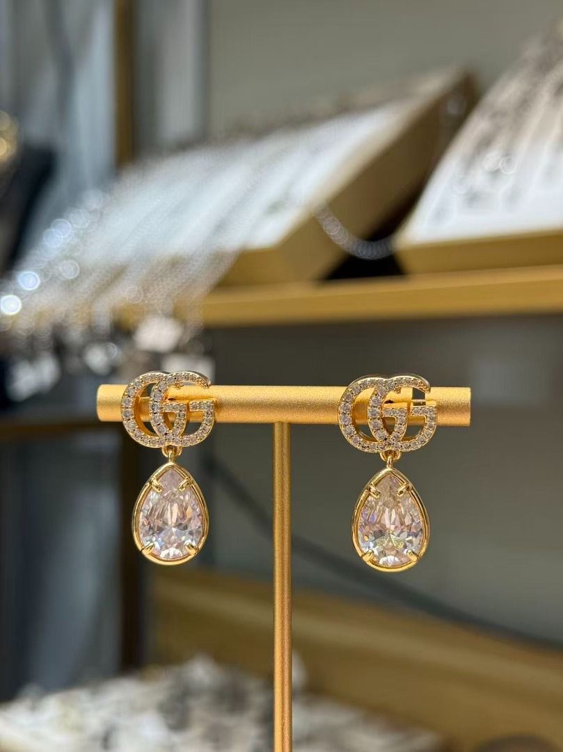 Gucci GG Crystal Drop Earrings (Category: Earrings) located in Davao. Submitted by colacodawr20358 (Listing ID 1467687406, Image 1). Description: - Authentic Gucci gold-tone earrings - Features crystal-encrusted Double G logo with dangling large teardrop crystals - Secure post back closure - Hallmarked with Gucci and Made in Italy stamps - Comes complete with green packaging bag and controllato card - Excellent condition, a stunning statement pie