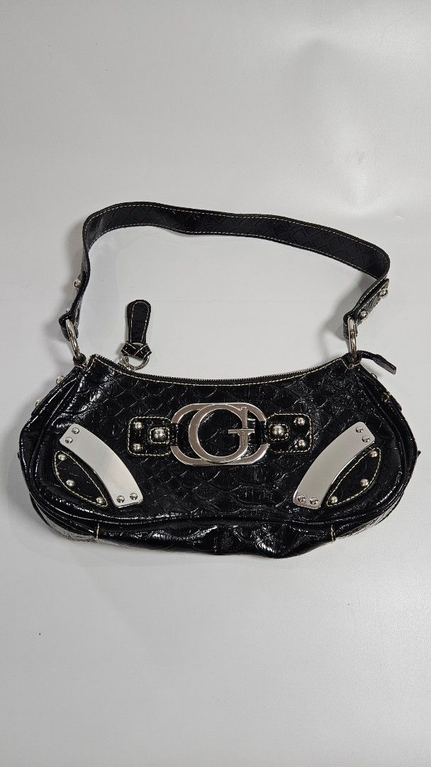 Guess Black Croc-Embossed Shoulder Bag (Category: Shoulder Bags) located in Alfonso. Submitted by jbcamet (Listing ID 1467709182, Image 1). Description: - Brand: Guess - Style: Shoulder bag - Material: Faux crocodile texture with polished finish - Hardware: Chunky silver-tone with large front G logo ring and metal corner accents - Closure: Top zipper - Interior: Classic monogram fabric lining, zip pocket, and Guess brand plaque - Strap: Short sho