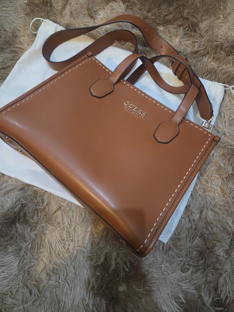 Guess Silvana 2 Compartment Tote Bag (Category: Cross-body Bags) located in Paranaque City. Submitted by mauandchelliedeclutters (Listing ID 1467771689, Image 3). Description: GUESS Tan/Cognac Leather Satchel Tote Bag with Crossbody Strap (Like New) ​ ₱2k only! ​ RFS: Someone in the fam got hospitalized, need funds. please dont haggle too low :( ​- classic tan/cognac brown finish - stylish stitch detailing along the edges, dual top handles, and a
