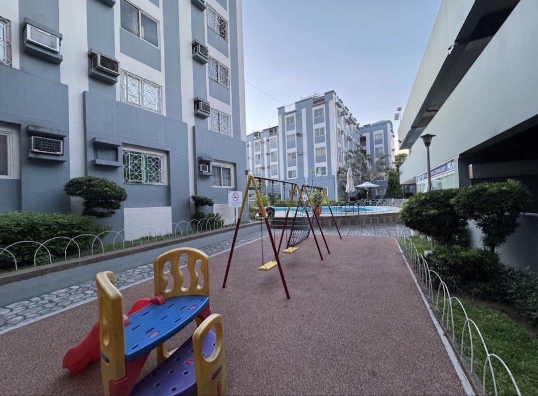 Hampstead Gardens Condominium Property with Pool and Amenities (Category: Apartments & Condos) located in Manila. Submitted by tineemall (Listing ID 1467711607, Image 3). Description: Dues included - Location: Hampstead Gardens - Environment: Peaceful, quiet neighborhood surrounded by trees and paved walkways - Amenities: Outdoor swimming pool and children's playground - Security: Gated entrance with 24/7 security - Property Type: Multi-story res
