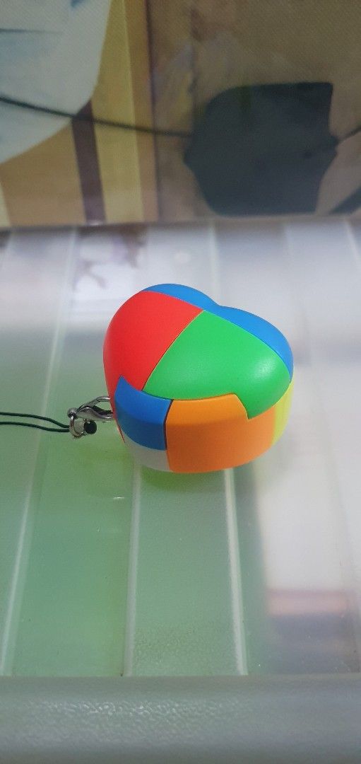 Heart Luban Lock Puzzle Keychain (Category: Board Games & Puzzles) located in Quezon City. Submitted by collectionneursonline88 (Listing ID 1467812660, Image 2). Description: - Adorable heart-shaped design with vibrant multi-colored panels (red, green, blue, orange, yellow) - Smooth and easy rotation for a satisfying fidget and brain teaser experience - Comes with a secure black strap and metal clasp - Perfect size to use as a keychain or bag cha