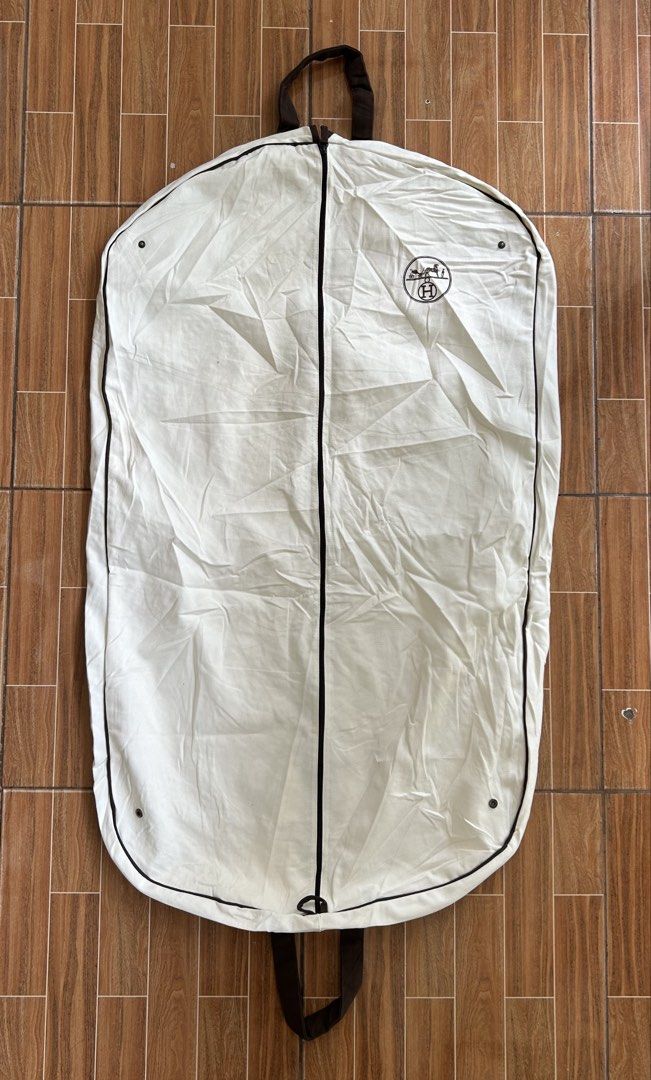 Hermès Canvas Garment Bag Dust Cover (Category: Luxury Accessories) located in Cagayan de Oro. Submitted by aljay02 (Listing ID 1467706491, Image 1). Description: - Color & Material: White heavy cotton weave canvas with brown trim and handles - Branding: Iconic Hermès carriage logo printed near the top right - Closure & Hardware: Full-length front zipper with bronze-tone snap buttons at the top and bottom corners - Ideal Use: Perfect for storing 