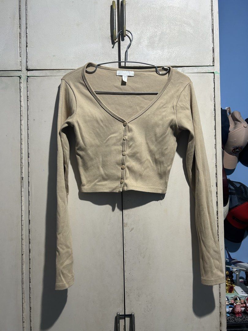 H&M Beige Ribbed Long Sleeve Buttoned Crop Top (Category: Longsleeves) located in Cavite. Submitted by michrolfe (Listing ID 1467683188, Image 1). Description: - Brand: H&M - Size: S - Color: Neutral beige - Style: V-neck, long sleeves, front button closure, cropped length - Fit: Slim and flattering for high-waisted bottoms - Material: Soft and stretchy fabric.