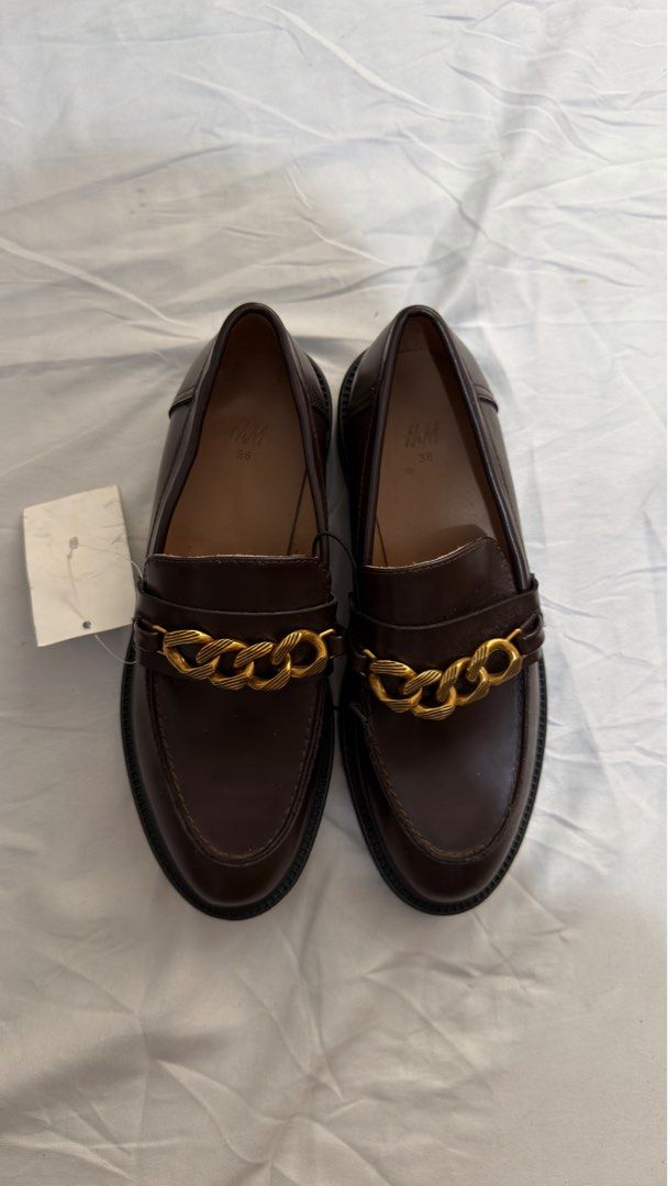 H&M Dark Brown Chain Loafers Size 36 (Category: Loafers) located in Pasig City. Submitted by _missdee (Listing ID 1467669107, Image 1). Description: - Brand: H&M - Style: Dark brown loafers with chunky gold chain detail and thick soles - Size: 36 (printed on inner sole) - Condition: Brand new, never worn out, store tag still attached - Type: Slip-on.