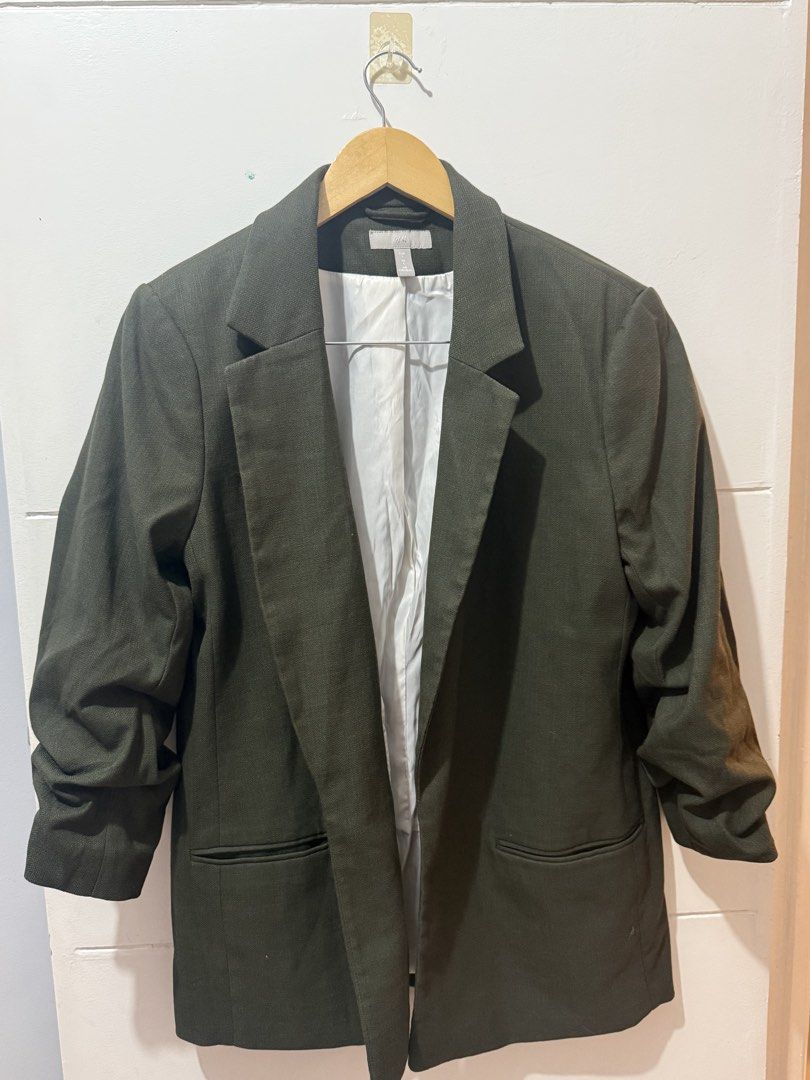 H&M Dark Green Blazer Size L (Category: Coats, Jackets and Outerwear) located in Batangas. Submitted by melocollects (Listing ID 1467714755, Image 1). Description: - Brand: H&M - Size: L - Color: Dark green with white interior lining - Design: Open front with lapels and two functional front pockets - Sleeves: Long sleeves with stylish ruched details - Style: Versatile piece, easy to throw over casual or smart casual outfits.