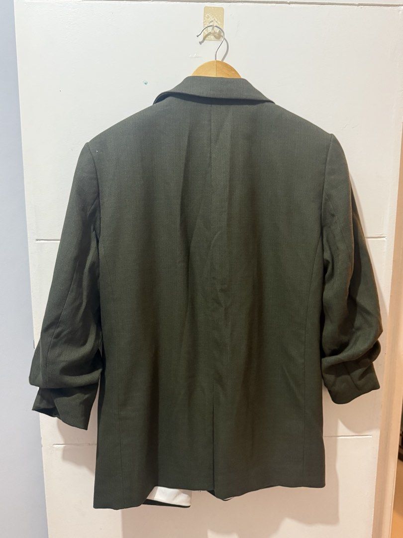 H&M Dark Green Blazer Size L (Category: Coats, Jackets and Outerwear) located in Batangas. Submitted by melocollects (Listing ID 1467714755, Image 3). Description: - Brand: H&M - Size: L - Color: Dark green with white interior lining - Design: Open front with lapels and two functional front pockets - Sleeves: Long sleeves with stylish ruched details - Style: Versatile piece, easy to throw over casual or smart casual outfits.