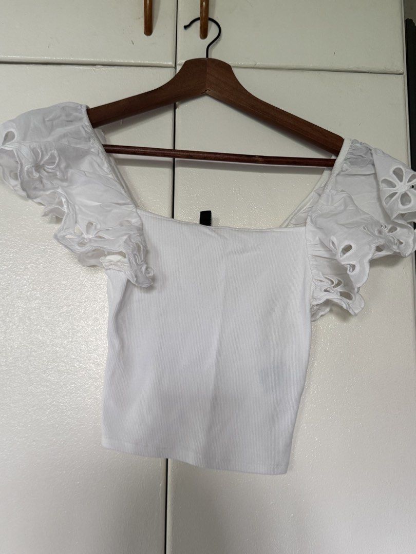 H&M Divided White Eyelet Ruffle Sleeve Crop Top (Category: Blouses) located in Iloilo. Submitted by trixiaaa18 (Listing ID 1467623261, Image 3). Description: - Brand: H&M Divided - Size: XS - Color: Clean White - Material: Stretchy ribbed fabric - Design: Square neckline with cut-out flower eyelet ruffles on sleeves - Condition: Excellent, clean.