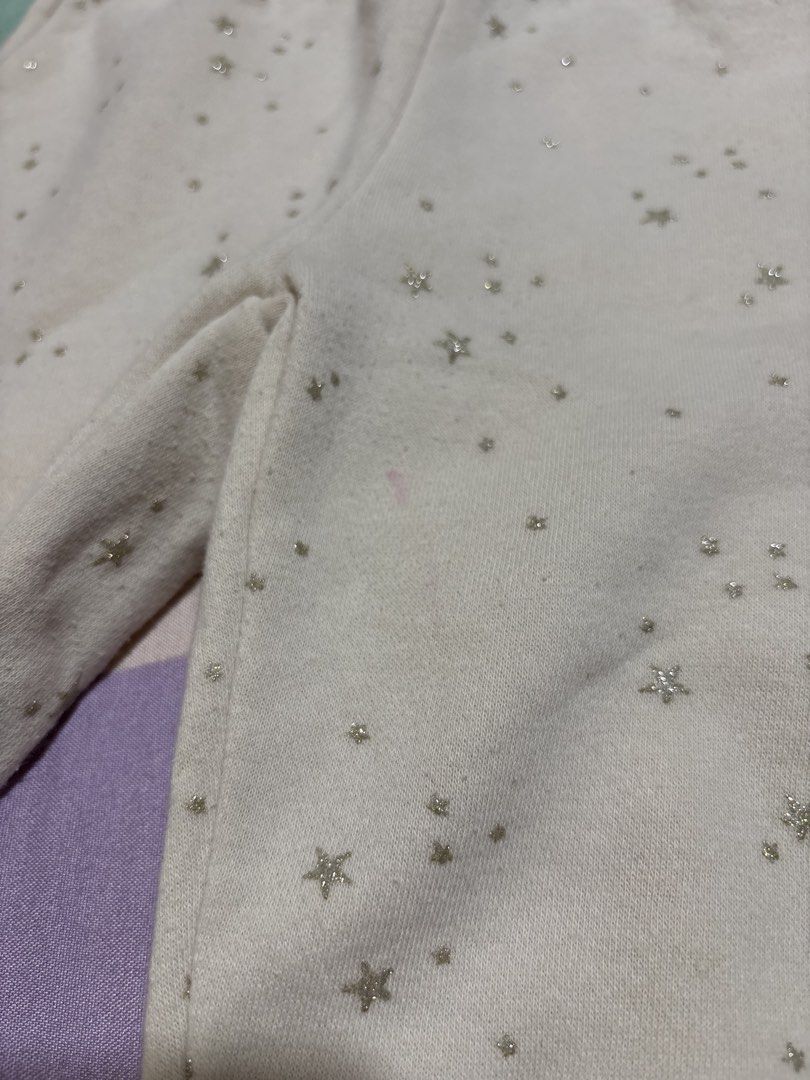 H&M Star Print Sweatpants Joggers (Category: Babies & Kids Fashion) located in Manila. Submitted by wardrobeinmnl (Listing ID 1467690981, Image 2). Description: - Brand/Item: H&M Beige Sweatpants with Sparkly Gold Stars - Size: EUR 104, US 4T, 3-4 Years - Material: Comfortable cotton blend with soft fleece lining - Features: Elastic waistband, adjustable drawstring, and ribbed ankle cuffs - Condition: Pre-loved with a slight pink stain near the f