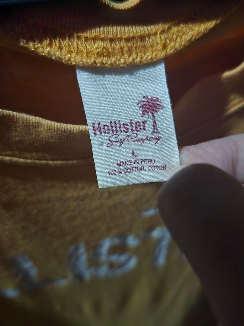 Hollister Mustard Yellow Graphic Tee (Category: Tshirts & Polo Shirts ) located in Dagupan City. Submitted by chislocker14 (Listing ID 1467605965, Image 2). Description: - Brand: Hollister - Size: Large on tag but can only fit s-m - Color: Mustard Yellow - Material: 100% Cotton (Made in Peru) - Style: Classic crew neck, short sleeves - Design: Large white logo graphic on the front - Condition: Soft knit with natural wear and a couple of tiny mino