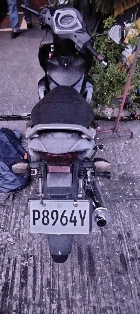 Honda Wave 125R Motorcycle (Category: Motorbikes for Sale) located in Mandaluyong City. Submitted by dhaliwal086 (Listing ID 1467709720, Image 2). Description: Honda Wave 125R motorcycle in black and red. Mileage reads 52631 kilometers. Fuel gauge sits near empty. Chain drive system with stock exhaust pipe. Standard step bars and grab handle attached. License plate reads P8964Y. Engine starts and runs fine. Normal wear from daily commuting..