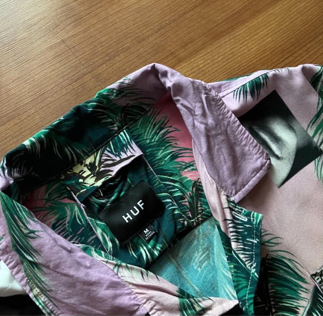 HUF Palm Tree (Category: Tshirts & Polo Shirts ) located in Rizal. Submitted by timelessfinds89_ (Listing ID 1467629288, Image 2). Description: - Brand/Model: HUF Short Sleeve Button-Up Shirt - Size: Medium - Design: Pink and green palm tree graphic print with black and white face photo collages - Material: Soft and lightweight rayon and viscose blend - Details: Classic collar, front button closure, left chest pocket, and extra buttons attached t