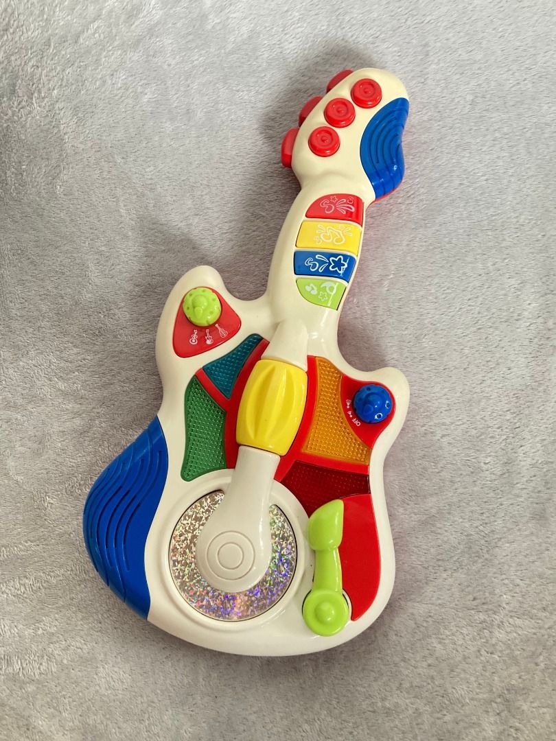 Interactive musical toy guitar (Category: Kids Toys) located in Rizal. Submitted by sheeraay (Listing ID 1467706489, Image 2). Description: - Interactive buttons on neck and body play fun melodies and notes - Spinning center disc with eye-catching holographic details - Green musical note toggle switch at the bottom - Perfect for toddlers and kids learning to explore music -Working battery operated.