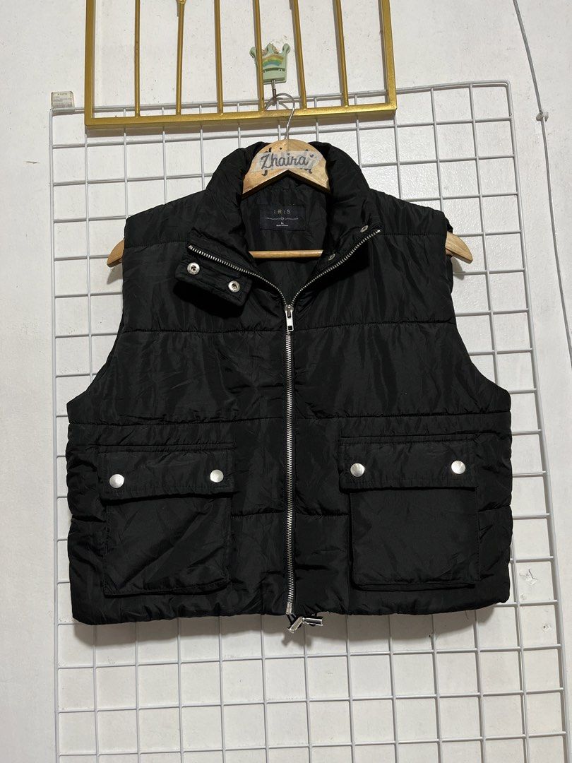 Iris Black Cropped Puffer Vest Size L (Category: Coats, Jackets and Outerwear) located in Pagsanjan. Submitted by zhairaaaaa (Listing ID 1467745978, Image 2). Description: - Brand/Model: Iris black puffer vest - Size: L - Closure: Zip-up front with snap buttons and a high collar - Pockets: Two front utility pockets with metal snap closures - Design: Classic quilted pattern throughout , cropped puffy style. - Condition: Clean inside and out, perfe