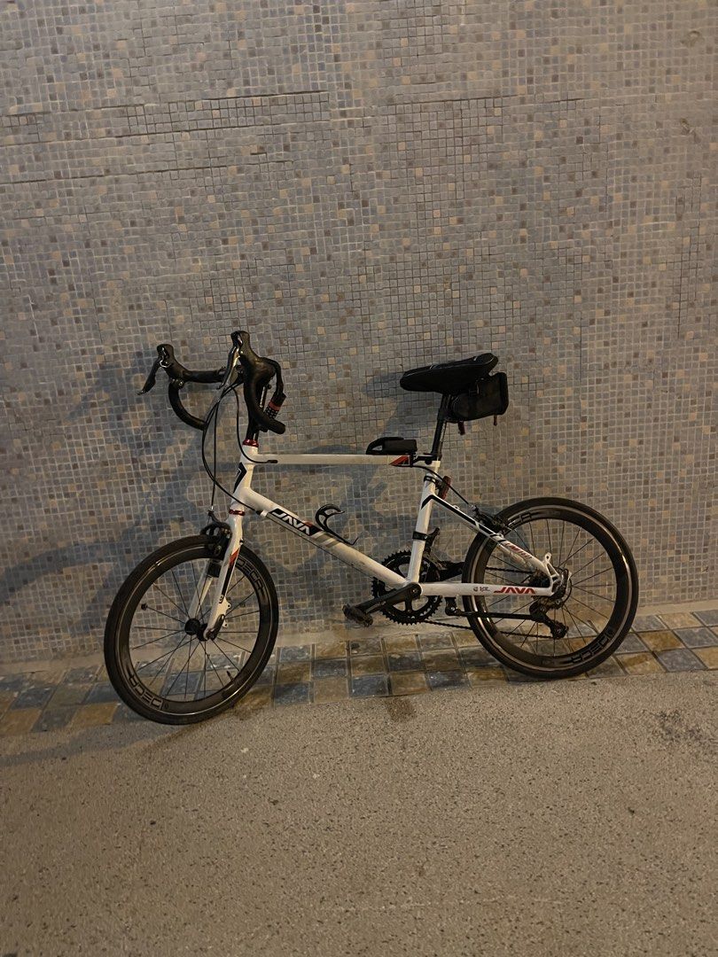 Java Road Bike （分類：單車）位於 Hong Kong。 由 uzairjatt291075 提交（商品編號 1467757911，圖片 1）。簡介： Java drop bar minivelo in white. Shimano Sora rear derailleur installed. Dual chainrings up front. Drop handlebars wrapped in black tape. Deep section wheels with Deca branding. Frame has some dirt buildup and chain shows significant rust. Needs a thorough clean and tune-up before hitting the road. Pick up only.。
