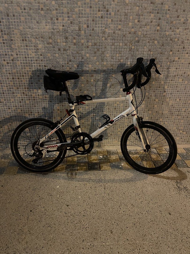 Java Road Bike （分類：單車）位於 Hong Kong。 由 uzairjatt291075 提交（商品編號 1467757911，圖片 2）。簡介： Java drop bar minivelo in white. Shimano Sora rear derailleur installed. Dual chainrings up front. Drop handlebars wrapped in black tape. Deep section wheels with Deca branding. Frame has some dirt buildup and chain shows significant rust. Needs a thorough clean and tune-up before hitting the road. Pick up only.。