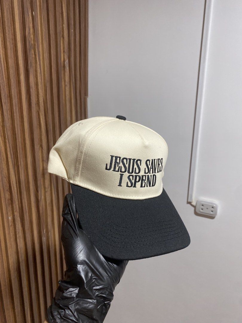 Jesus Saves I Spend Embroidered Cap Cream Black (Category: Caps & Hats) located in Caloocan City. Submitted by heatedcaps4425 (Listing ID 1467802463, Image 2). Description: - Condition: Brand new, never worn (original paper insert still inside) - Design: Cream and black 5-panel structured baseball cap - Embroidery: 'JESUS SAVES I SPEND' text on the front - Fit: Adjustable strap with metal slider in the back - Material: 100% cotton (Made in China)