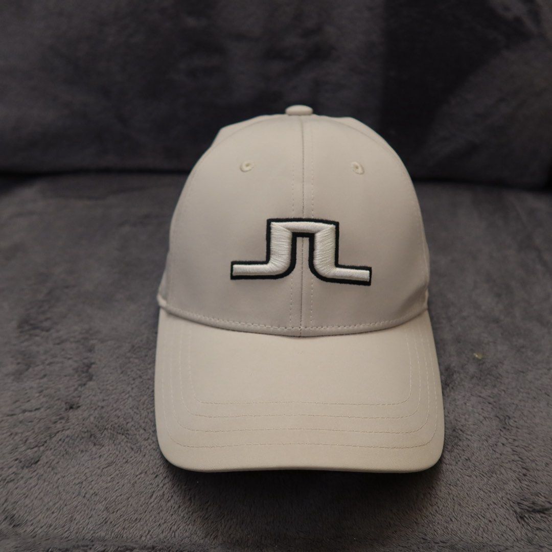 j.lindeberg Cap One Size Beige (Category: Caps & Hats) located in Manila. Submitted by gentlewind_62f064 (Listing ID 1467616991, Image 1). Description: - Brand: J.Lindeberg - Color: Neutral beige with black & white embroidered bridge logo - Design: Structured 6-panel with top eyelets and curved brim - Size: One Size (adjustable strap) - Condition: Excellent, clean interior and exterior with no noticeable flaws - Origin: Made in China.