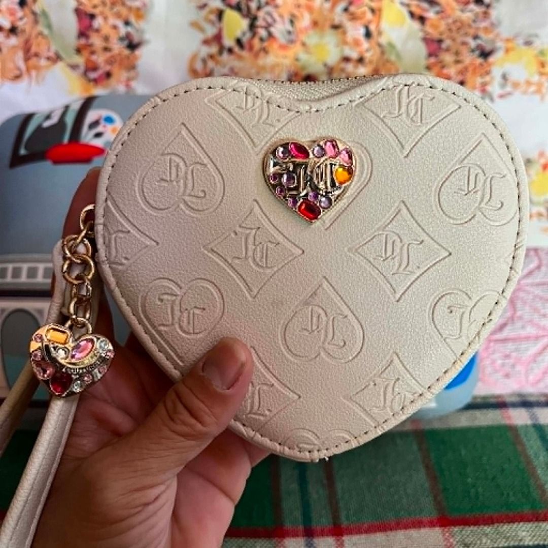 Juice Couture White Heart Embossed Wristlet (Category: Purses & Pouches) located in Cebu City. Submitted by islanevaeh85 (Listing ID 1467646902, Image 2). Description: - Brand: Juicy Couture - Color: White with multi-color rhinestone heart embellishment - Design: All-over debossed monogram pattern with zip closure - Features: Matching wrist strap with an extra heart charm and custom logo interior lining - Size: Compact and handy for essentials li