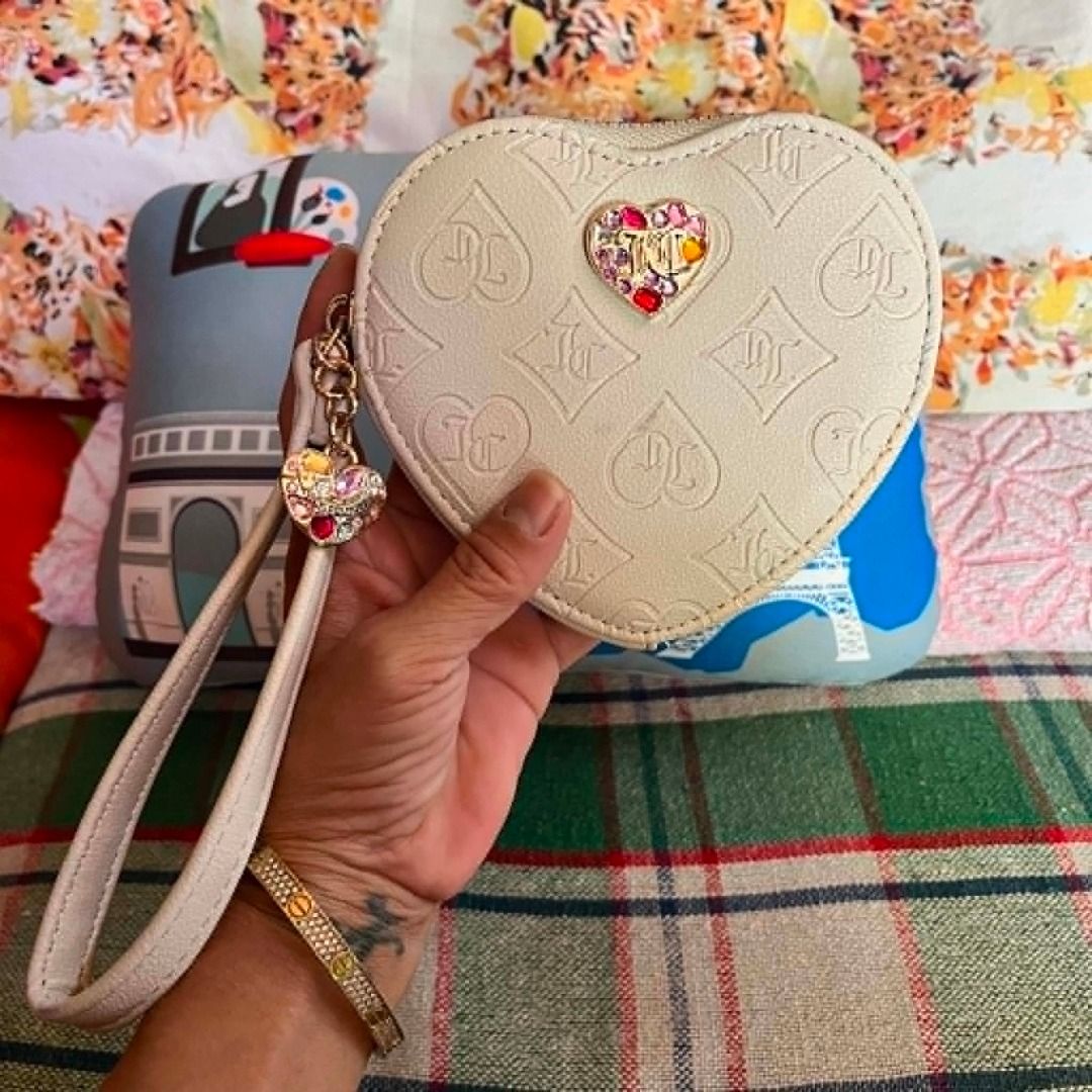 Juice Couture White Heart Embossed Wristlet (Category: Purses & Pouches) located in Cebu City. Submitted by islanevaeh85 (Listing ID 1467646902, Image 1). Description: - Brand: Juicy Couture - Color: White with multi-color rhinestone heart embellishment - Design: All-over debossed monogram pattern with zip closure - Features: Matching wrist strap with an extra heart charm and custom logo interior lining - Size: Compact and handy for essentials li