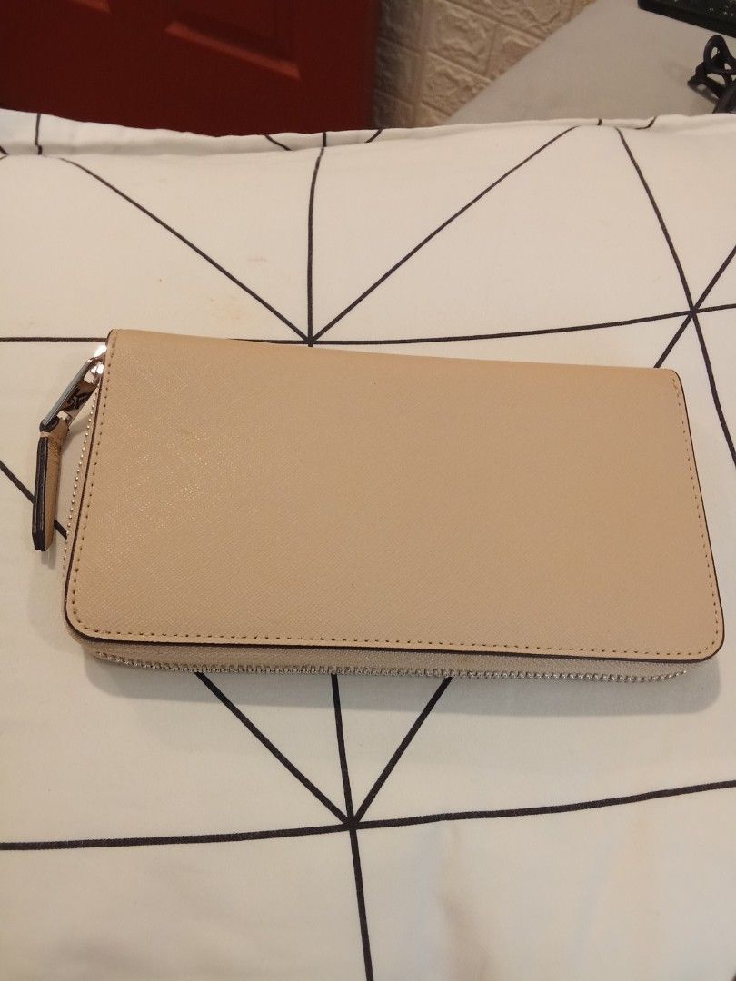 Karl Lagerfeld beige zip around wallet (Category: Wallets & Card holders) located in Las Pinas. Submitted by Gienuine (Listing ID 1467614937, Image 2). Description: - Brand: Karl Lagerfeld - Color: Elegant beige - Material: Textured faux leather with clean exterior stitching - Hardware & Branding: Striking silver metallic front branding with matching zipper pull tab - Design: Structured shape featuring a chic V-flap detail - Storage: Secure zip-a