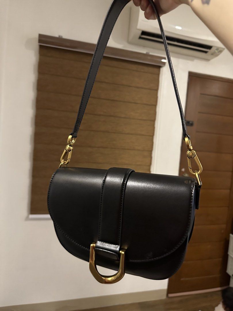 Keith & Charles Black Saddle Shoulder Bag (Category: Shoulder Bags) located in Manila. Submitted by anniesam (Listing ID 1467741436, Image 1). Description: - 💯 Guaranteed Authentic : Charles & Keith Slightly negotiable - Material: Black leather - Design: Structured saddle shape with gold-tone U-buckle closure - Strap: Removable strap with gold hardware hooks and logo branding - Closure: Secure magnetic snap closure - Interior: Clean lining with 