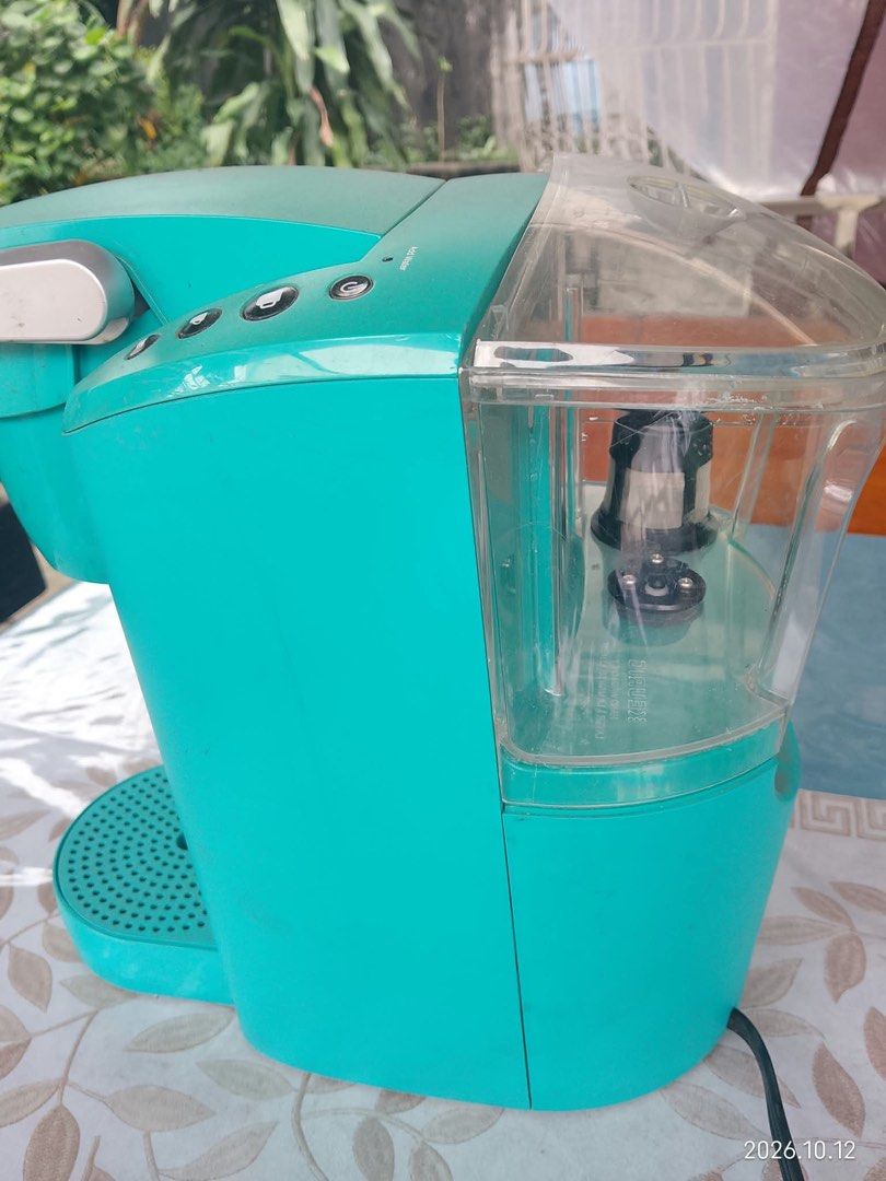 Keurig Coffee Maker Teal Blue Single Serve (Category: Coffee Machines & Makers) located in Quezon City. Submitted by mjgaudier (Listing ID 1467614025, Image 2). Description: - Color: Bright teal - Type: Single-serve coffee maker - Compatibility: Works with standard coffee pods - Included: Water reservoir with filter attachment and drip tray - Features: Easy-to-open needle housing, simple top-panel power and cup size buttons - Condition: Clean bod