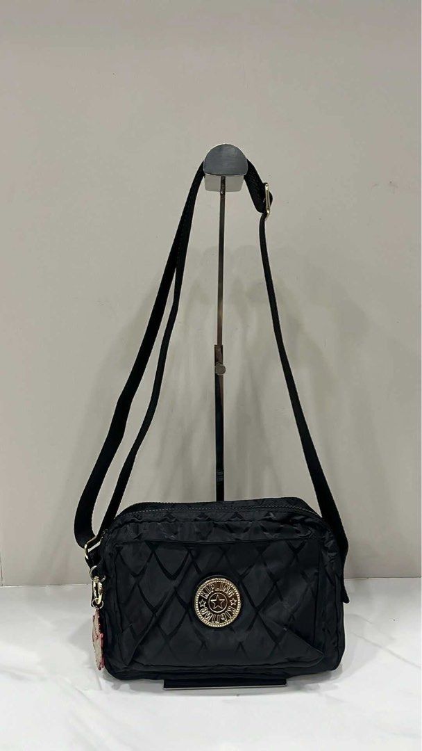 Kipling Black Quilted Crossbody Bag (Category: Cross-body Bags) located in Cavite. Submitted by alyssa122898 (Listing ID 1467664080, Image 1). Description: - Brand: Kipling - Material: Durable black crinkle nylon with diamond quilting - Design: Circular logo badge on front pocket with side charm - Closure: Secure top zip - Strap: Adjustable black webbed shoulder/crossbody strap - Capacity: Spacious enough for phone, wallet, and daily essentials.