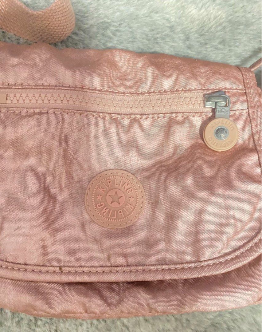 Kipling Rose Gold Crossbody Bag (Category: Cross-body Bags) located in Cebu City. Submitted by jamaica_perez (Listing ID 1467773011, Image 2). Description: Authentic, no issues unless stated so. Available pa hanggat di minark as sold. Prices negotiable. Wag na mag message pag di din bibili. Save us both some time. - Color: Trendy Rose Gold - Brand: Authentic Kipling - Pocket: Convenient zippered front pocket - Logo: Iconic round Kipling logo patc