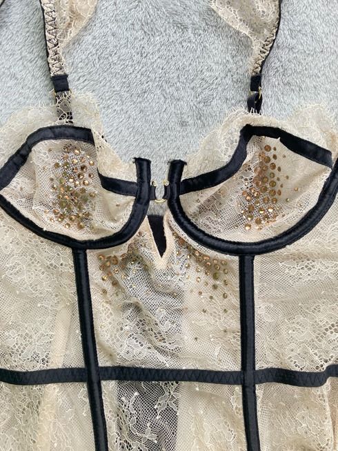 Lace Rhinestone Corset (Category: Undergarments & Loungewear) located in Rizal. Submitted by sheeraay (Listing ID 1467650324, Image 3). Description: - Brand: Victoria's Secret - Size: 34B - Color/Style: Beige lace overlay with contrasting black trim piping - Details: Sparkling rhinestone embellishments on front cups and bodice - Support: Built-in underwire - Closure: Hook-and-eye back closure - Straps: Adjustable - Material: Nylon and elastane bl