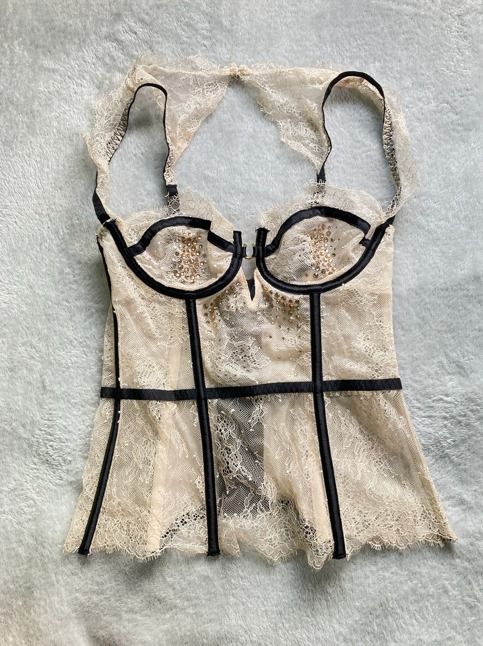 Lace Rhinestone Corset (Category: Undergarments & Loungewear) located in Rizal. Submitted by sheeraay (Listing ID 1467650324, Image 2). Description: - Brand: Victoria's Secret - Size: 34B - Color/Style: Beige lace overlay with contrasting black trim piping - Details: Sparkling rhinestone embellishments on front cups and bodice - Support: Built-in underwire - Closure: Hook-and-eye back closure - Straps: Adjustable - Material: Nylon and elastane bl