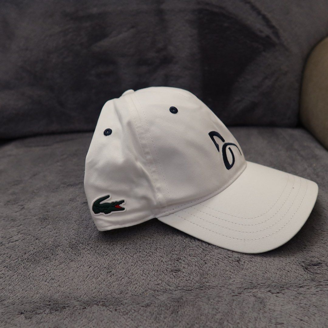 Lacoste Sport White Tennis Cap (Category: Caps & Hats) located in Manila. Submitted by gentlewind_62f064 (Listing ID 1467616936, Image 2). Description: - Brand: Lacoste Sport - Model: TH1044 - Color: White with navy blue embroidered branding - Logo: Iconic green crocodile patch on the side - Size: One size fits all (adjustable strap in the back) - Condition: Clean inside and out, ready to wear.