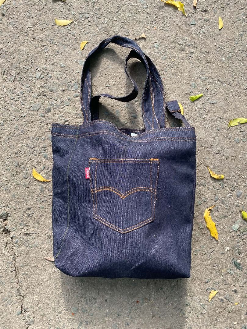 Levi's Denim Tote Bag with Pockets (Category: Belt bags, Clutches and Pouches) located in Pasay City. Submitted by goldentree.711b44 (Listing ID 1467805645, Image 2). Description: - Crafted from durable dark wash denim with classic orange contrast stitching - Features an authentic Levi's pocket on the front with the iconic red tab - Comes with a matching small zip pouch for your coins or small essentials - Handy outer slip pockets designed for ea
