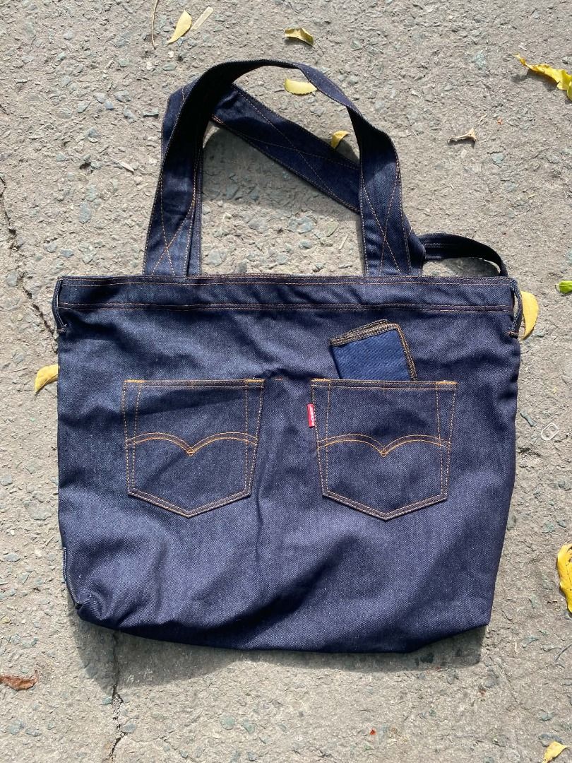Levi's Denim Tote Bag with Pockets (Category: Belt bags, Clutches and Pouches) located in Pasay City. Submitted by goldentree.711b44 (Listing ID 1467805645, Image 3). Description: - Crafted from durable dark wash denim with classic orange contrast stitching - Features an authentic Levi's pocket on the front with the iconic red tab - Comes with a matching small zip pouch for your coins or small essentials - Handy outer slip pockets designed for ea