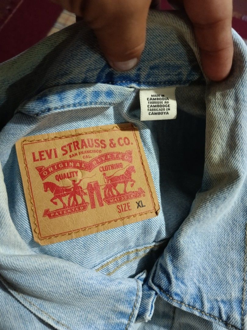 Levi's Light Wash Denim Jacket Size XL (Category: Coats, Jackets and Outerwear) located in General Santos City (Dadiangas). Submitted by freehorse.5f2a61 (Listing ID 1467651896, Image 3). Description: - Brand: Levi's - Style: Classic denim jacket in light wash blue - Size: XL - Features: Button-up front, dual chest pockets, branded metal hardware, and signature red Levi's tab - Origin: Made in Cambodia - Condition: Excellent, ready to wear W 26 L