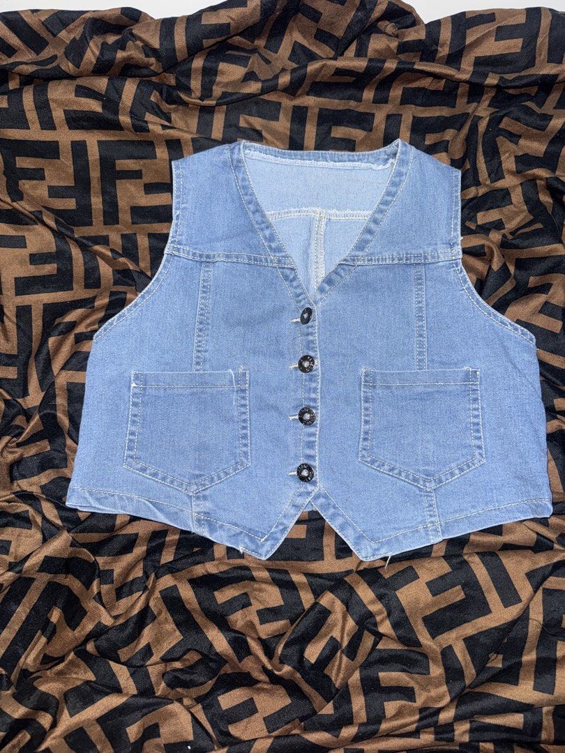 Light blue denim button-down vest with pockets (Category: Sleeveless) located in Manila. Submitted by angelovesbuldak (Listing ID 1467799497, Image 2). Description: - Style: Light blue wash denim vest - Neckline & Closure: V-neck with black front buttons - Pockets: Two front utility pockets near the hem - Design: Sleeveless with a trendy pointed hem - Versatility: Great for casual everyday wear and easy layering over tees or dresses - Look: Class