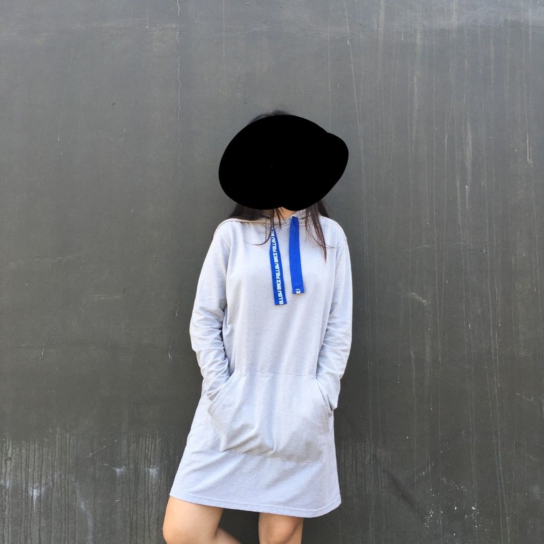 Light grey hoodie dress with blue drawstrings (Category: Dresses) located in Macabebe. Submitted by nelleeyyy.1 (Listing ID 1467626579, Image 1). Description: - Color: Light grey - Length: Above the knee - Style: Casual fit hoodie dress - Features: Long sleeves and front kangaroo pocket - Details: Thick blue drawstrings with white text print - Material: Soft and comfortable fabric - Best for: Running errands, casual hangouts, or everyday wear.