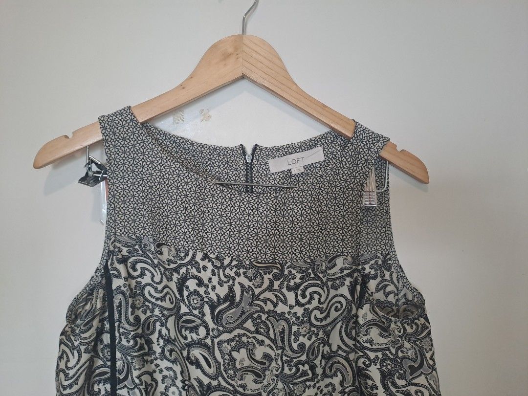 Loft by Anne Taylor sleeveless (Category: Sleeveless) located in Manila. Submitted by joanbalde39643 (Listing ID 1467659611, Image 2). Description: This is a women's sleeveless mixed-print blouse from the clothing brand LOFT. The shirt features a contrasting panel design with a small geometric or micro-floral pattern across the upper yoke and a classic black-and-white paisley print throughout the main body. It is accented with vertical black trim