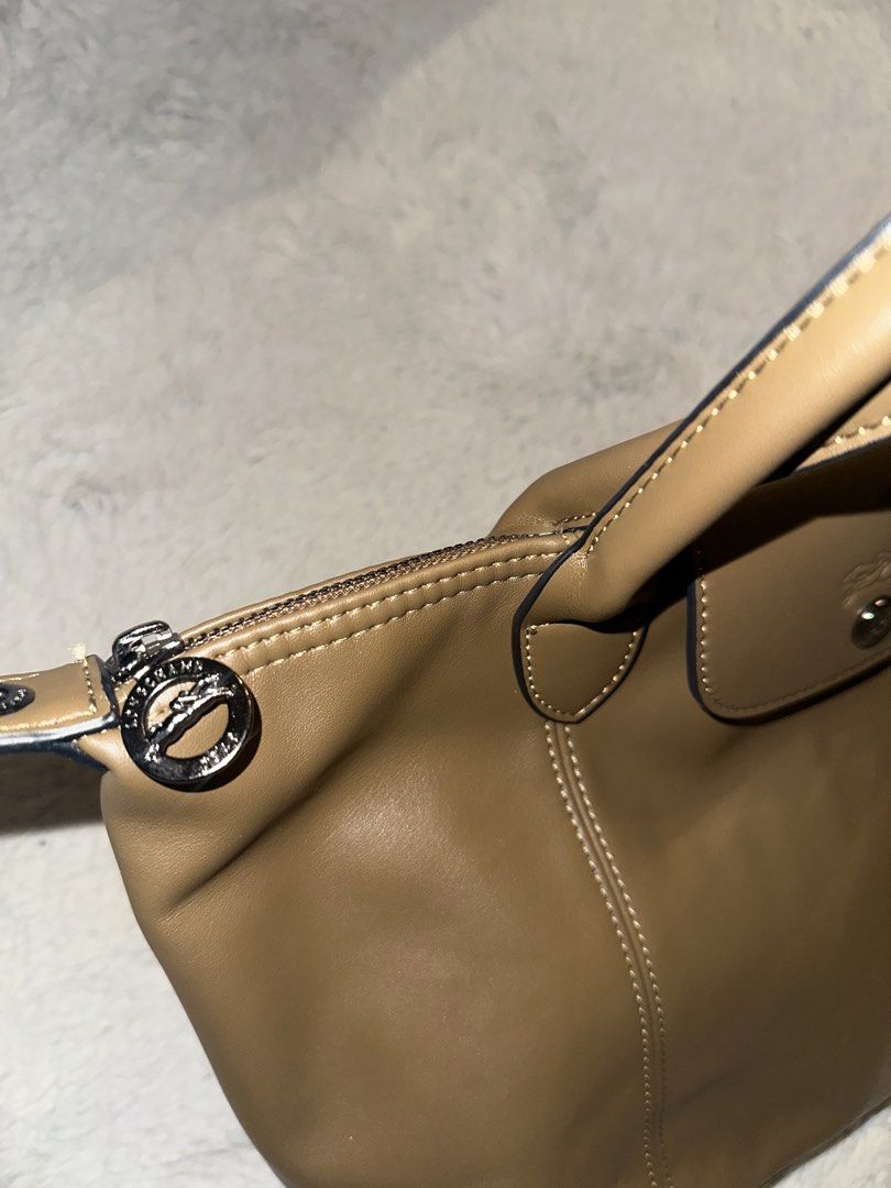 Longchamp Brown Leather Top Handle Bag (Category: Luxury Bags & Wallets) located in Taguig. Submitted by fort22 (Listing ID 1467793986, Image 3). Description: - Brand: Longchamp - Material: Premium brown leather with elegant contrast white stitching - Closure: Secure top zipper with logo pull tab + front flap with snap closure and embossed jockey logo - Interior: Clean patterned fabric lining with a convenient zip pocket - Inclusion: Adjustable a
