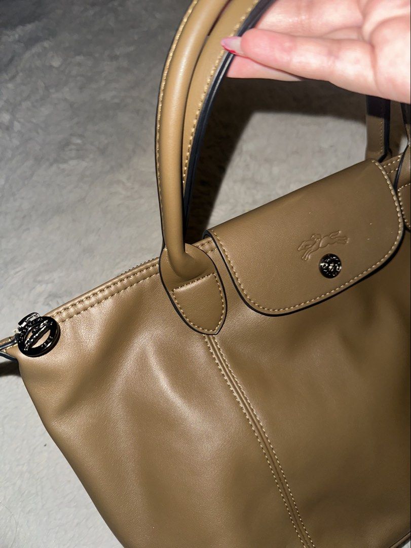 Longchamp Brown Leather Top Handle Bag (Category: Luxury Bags & Wallets) located in Taguig. Submitted by fort22 (Listing ID 1467793986, Image 2). Description: - Brand: Longchamp - Material: Premium brown leather with elegant contrast white stitching - Closure: Secure top zipper with logo pull tab + front flap with snap closure and embossed jockey logo - Interior: Clean patterned fabric lining with a convenient zip pocket - Inclusion: Adjustable a
