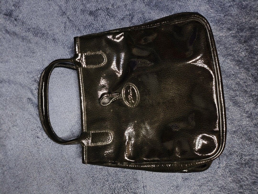 Longchamp Handbag Preloved (Category: Tote Bags) located in Las Pinas. Submitted by rose.luab (Listing ID 1467752899, Image 1). Description: Preloved Longchamp Roseau patent leather handbag Brand: Longchamp Line/Model: Roseau top-handle / totebag Material: Black glossy patent leather Key Feature: Distinctive silver- or gunmetal-tone bamboo-style pin and loop toggle..