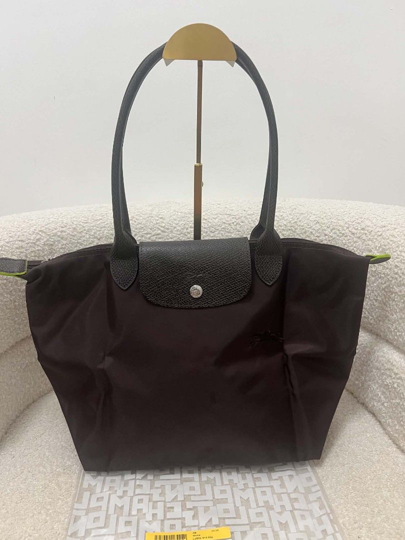 Longchamp Le Pliage Tote Bag Brown Mocha (Category: Tote Bags) located in Paoay. Submitted by rvf1230 (Listing ID 1467647457, Image 3). Description: - Authentic Longchamp Le Pliage Club tote bag - Color: Dark Brown / Mocha - Long shoulder handles for comfortable carrying - Secure top zipper closure and snap button leather flap - Durable nylon body with stylish contrast trim - Spacious interior fits all your daily essentials - what you see what yo