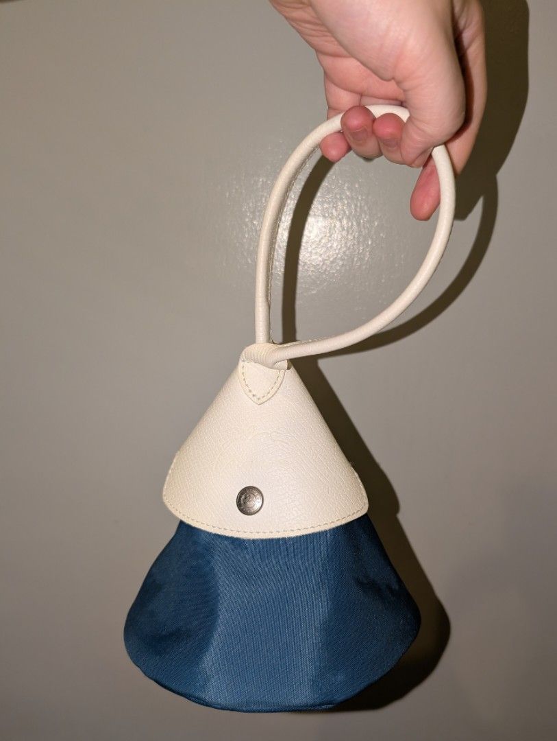 Longchamp x Nendo Cone Bag (Category: Luxury Bags & Wallets) located in Manila. Submitted by de.stijl (Listing ID 1467624447, Image 1). Description: - Authentic Longchamp pouch in dark blue nylon and cream leather. - Chic top handle style with secure zip closure. - Signature silver-tone hardware engraved with jockey logo and 1948. - Leather flap with snap button and original interior stamp. - Clean fabric lining with a well-maintained, structured