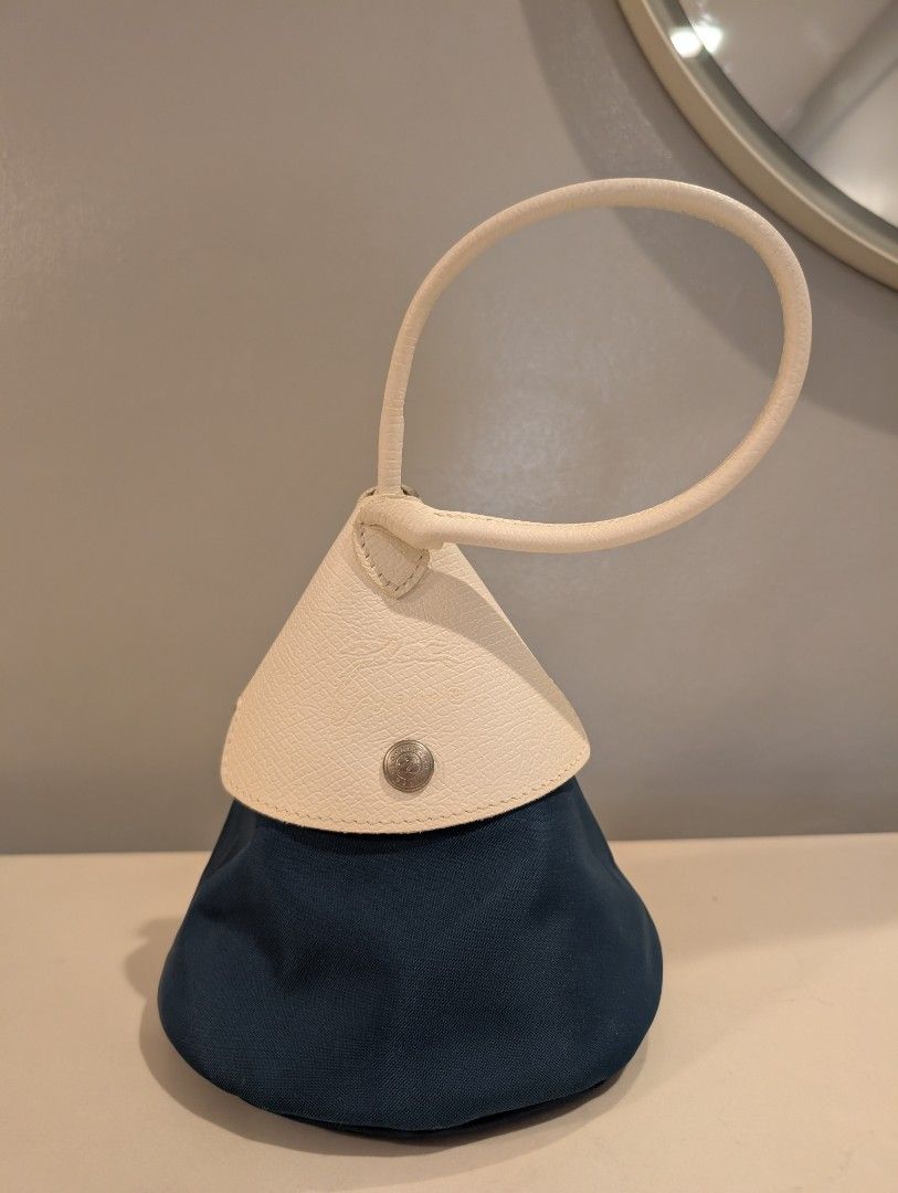 Longchamp x Nendo Cone Bag (Category: Luxury Bags & Wallets) located in Manila. Submitted by de.stijl (Listing ID 1467624447, Image 2). Description: - Authentic Longchamp pouch in dark blue nylon and cream leather. - Chic top handle style with secure zip closure. - Signature silver-tone hardware engraved with jockey logo and 1948. - Leather flap with snap button and original interior stamp. - Clean fabric lining with a well-maintained, structured