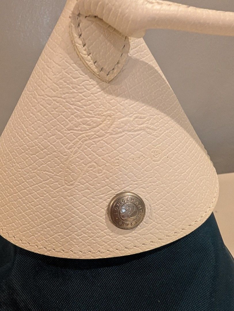 Longchamp x Nendo Cone Bag (Category: Luxury Bags & Wallets) located in Manila. Submitted by de.stijl (Listing ID 1467624447, Image 3). Description: - Authentic Longchamp pouch in dark blue nylon and cream leather. - Chic top handle style with secure zip closure. - Signature silver-tone hardware engraved with jockey logo and 1948. - Leather flap with snap button and original interior stamp. - Clean fabric lining with a well-maintained, structured