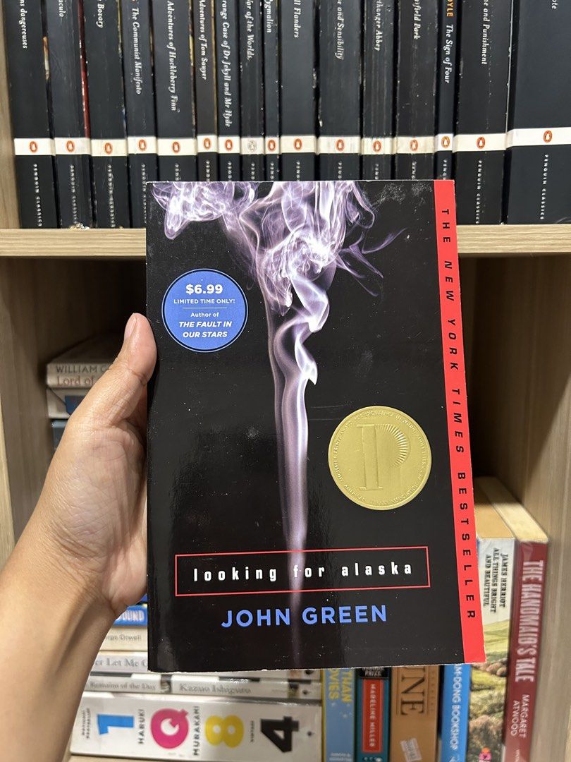 Looking for Alaska by John Green Paperback Novel (Category: Storybooks) located in Manila. Submitted by meannt. (Listing ID 1467774963, Image 1). Description: - Title: Looking for Alaska by John Green - Format: Paperback (Dutton edition) - Cover: Black with purple smoke graphics & gold Printz Award sticker - Edition: New York Times Bestseller - Condition: Clean pages, intact binding - Genre: Contemporary young adult fiction.