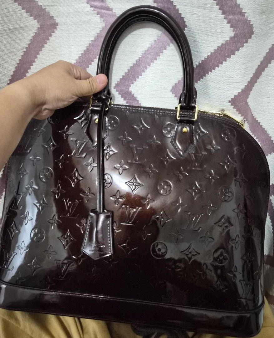 Louis Vuitton Alma Monogram Vernis Amarante Handbag (Category: Luxury Bags & Wallets) located in Caloocan City. Submitted by rmdesilva (Listing ID 1467735299, Image 1). Description: - Authentic Louis Vuitton Alma bag - Monogram Vernis leather in deep Amarante (glossy dark brown) - Structured dome shape with dual rolled top handles - Gold-tone hardware with double zip closure and LV pulls - Includes matching clochette with keys - Patent exterior i