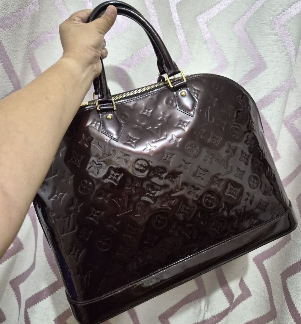 Louis Vuitton Alma Monogram Vernis Amarante Handbag (Category: Luxury Bags & Wallets) located in Caloocan City. Submitted by rmdesilva (Listing ID 1467735299, Image 2). Description: - Authentic Louis Vuitton Alma bag - Monogram Vernis leather in deep Amarante (glossy dark brown) - Structured dome shape with dual rolled top handles - Gold-tone hardware with double zip closure and LV pulls - Includes matching clochette with keys - Patent exterior i